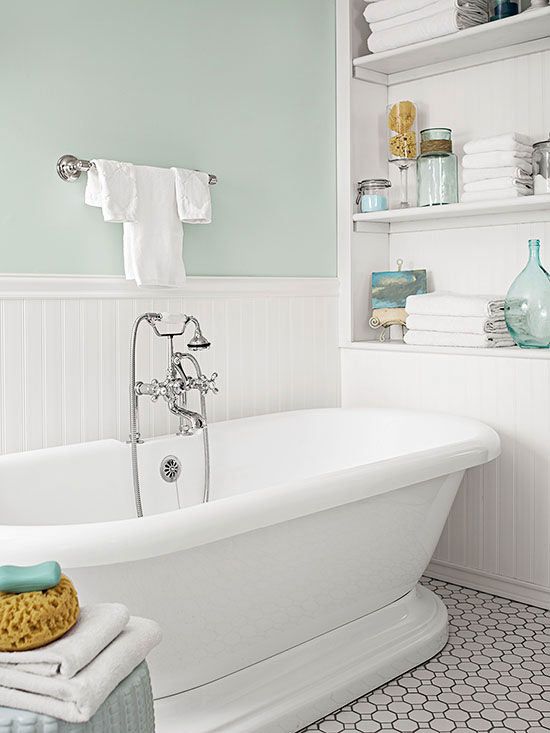 A bathroom with white and light gree duotone with a white tub