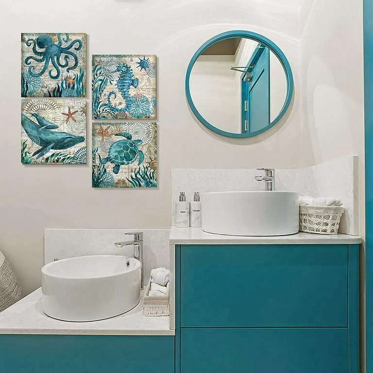A view of a coastal themed painting hung inisde a blue colored bathroom with a round mirror