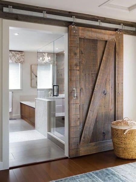 A view of a sliding barn door opening into a bathroom