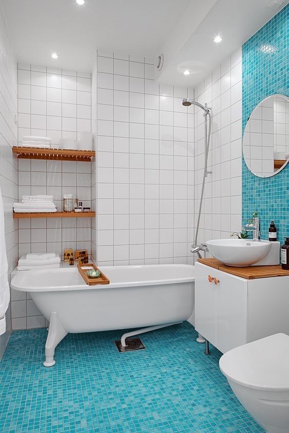 A view of blue sea glass on floor tiles of a while bathroom with white tiles on walls
