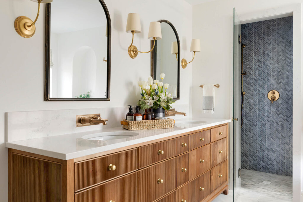 flowers palced on vanity in bathroom fixed faucets mirrors and lamps