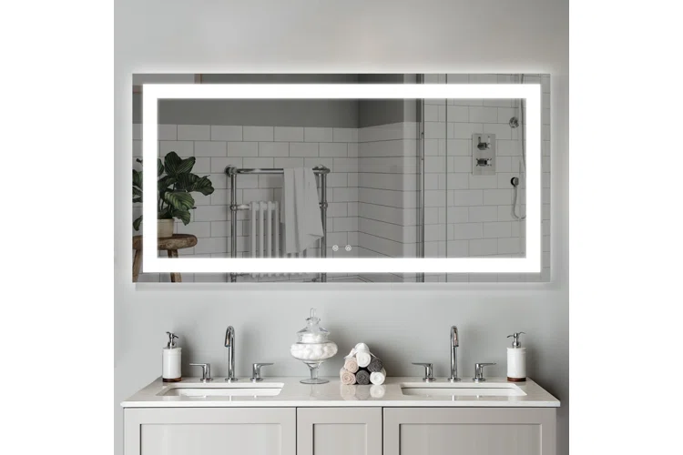 light fitted mirror on wall with white vanity and toilteries placed on sink