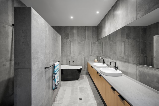 monochrome gray color in a bathrom with black bathtub sinks with black faucets