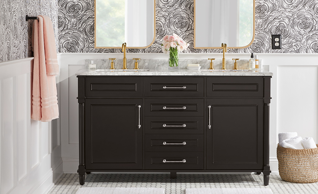 silver colored cabinet accents on black vanity in bathroom mirrors and faucets pink towel on the stand