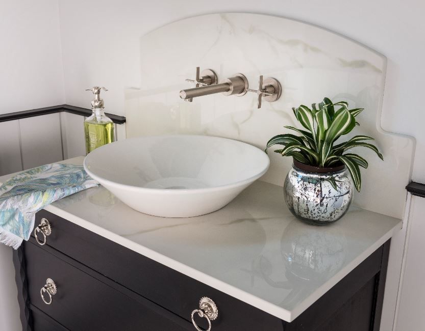 small basin in bathroom with black vanity plant place don side
