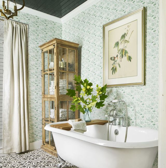 vertical storage shleves white bathtub plants and painting hung over tub in a bathroom