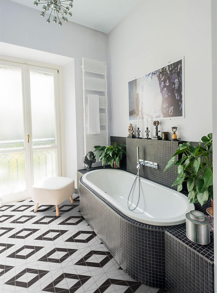 A view of a bathroom with a tub and square black and white tiles