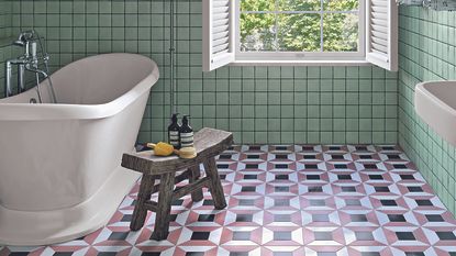 A view of a bathroom with a white tub and black and pink square tiles