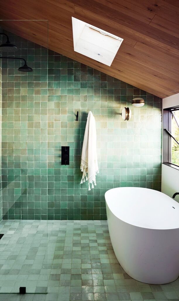 A view of a bathroom with green tiles