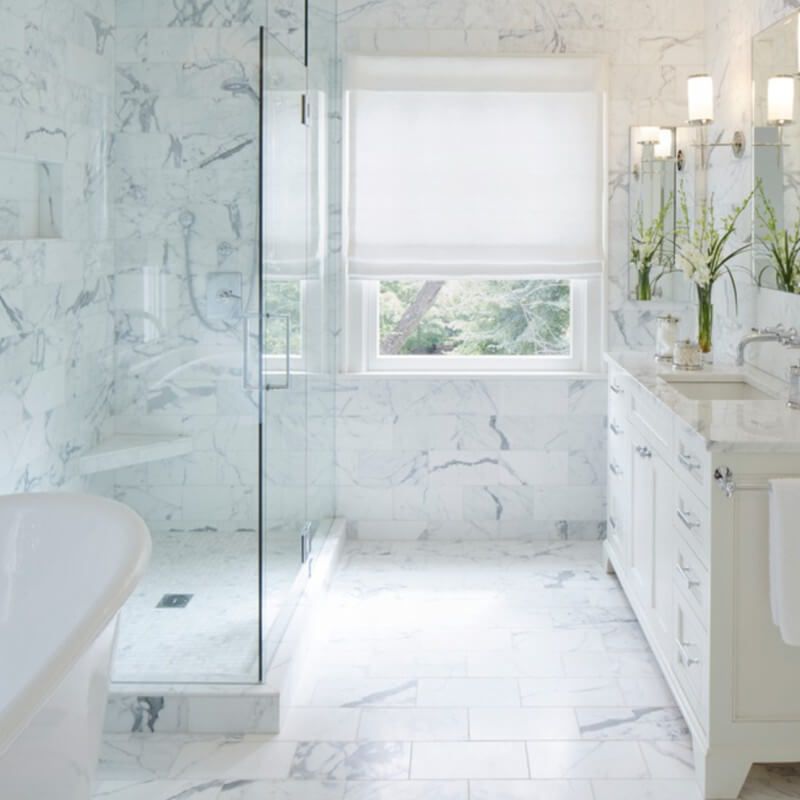 A view of a bathroom with white porcelain marble tiles