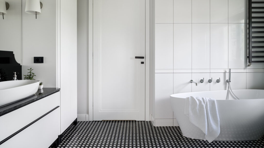 A view of glossy black and white dotted tiles inside a white bathroom