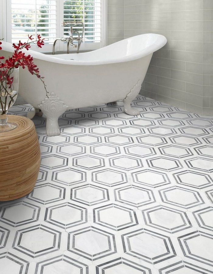 A view of grey hexagonical framing bath tiles with a white tub