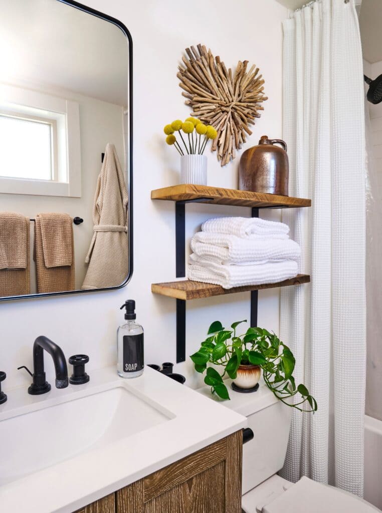 accessorized bathroom with shelves towels plants and decorative items placed on shelves