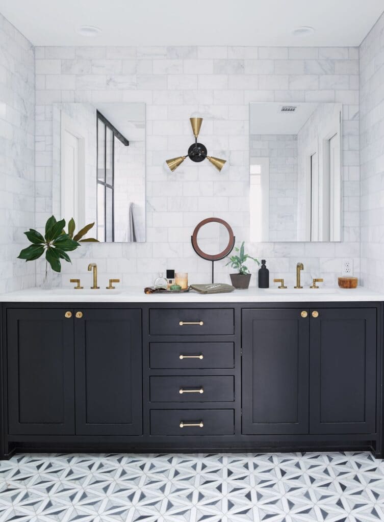 bathroom with black vanity gold accents and mirrors