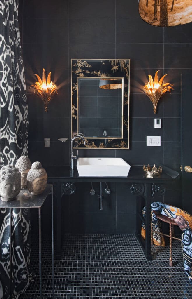 black and white eclectic bathroom with gold accents and sculptures placed on table