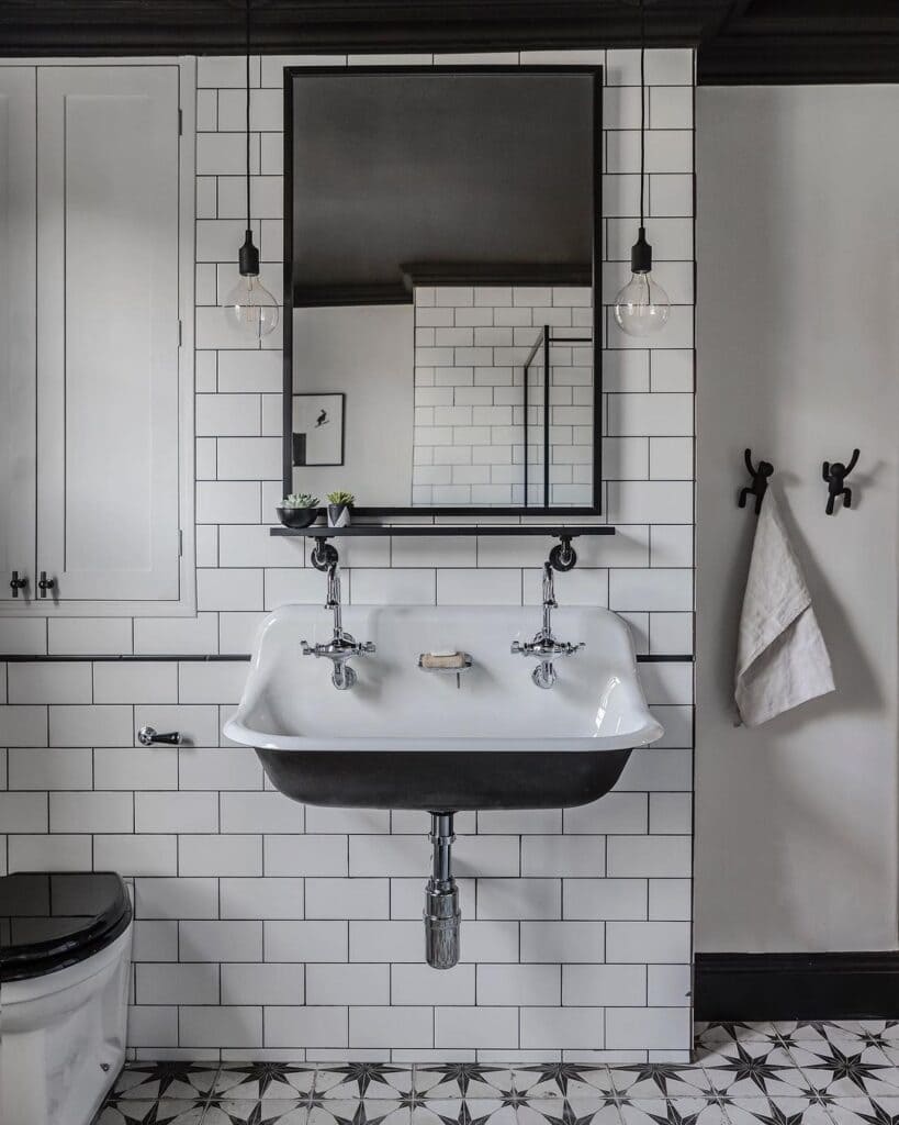 black and white tiles in a bathroom black accents and white sink