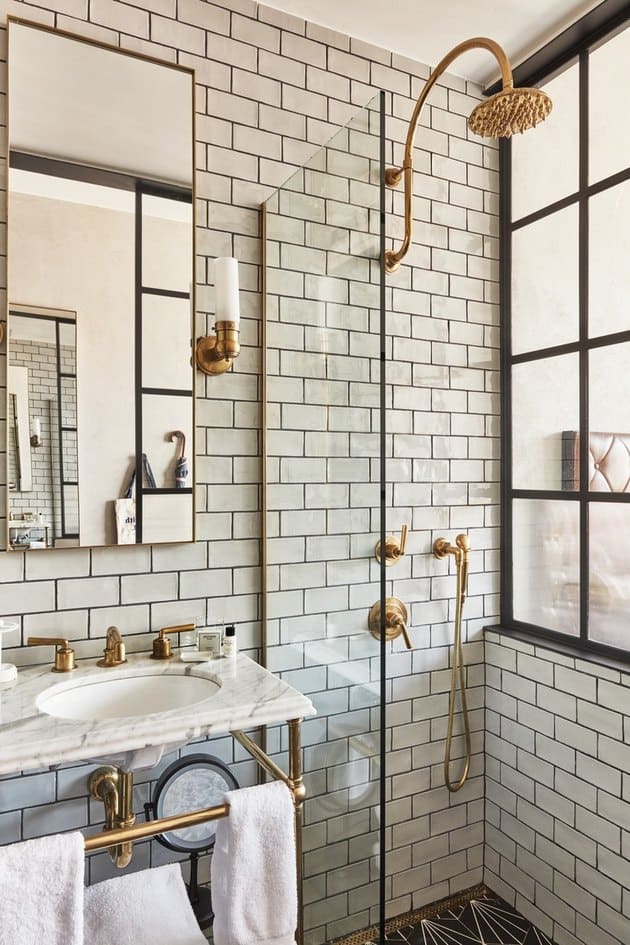 brass accents in bathroom with brass colored shower taps 