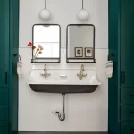 A view of a bathroom-sink with double mirrors attached above it