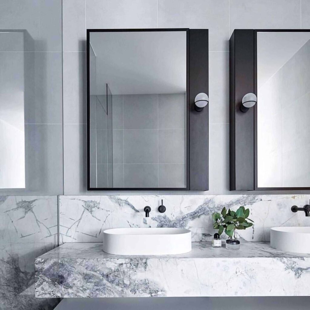 A view of a double medicine cabinet mirror over a bathroom sink