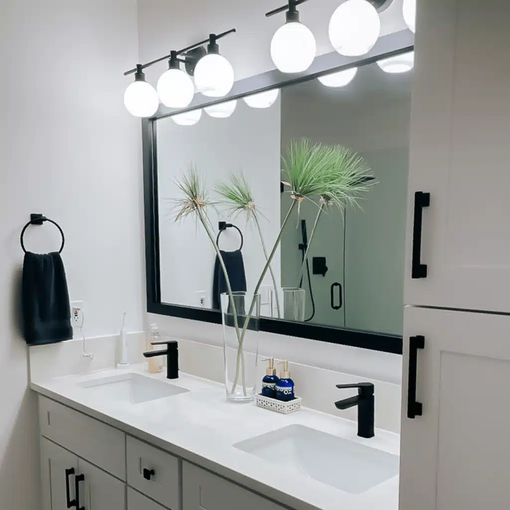 sinks and a single large mirror with light fixtures