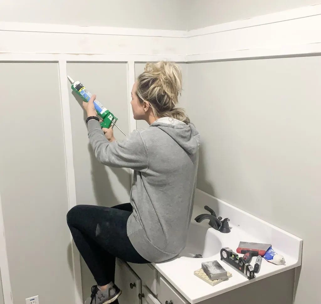 a female working on board and batten style holding a silicon gun