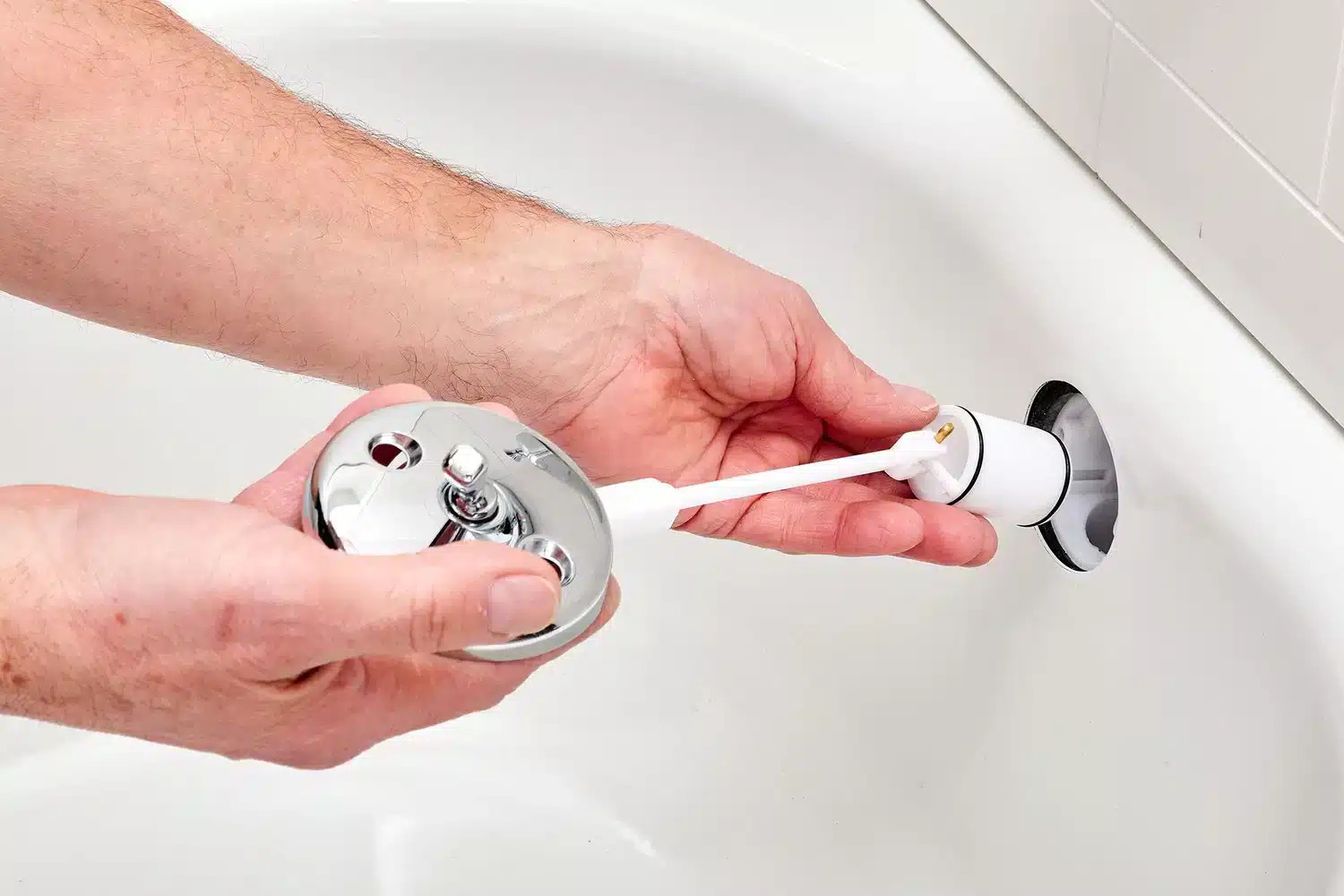 close up of hands working on a drain stopper