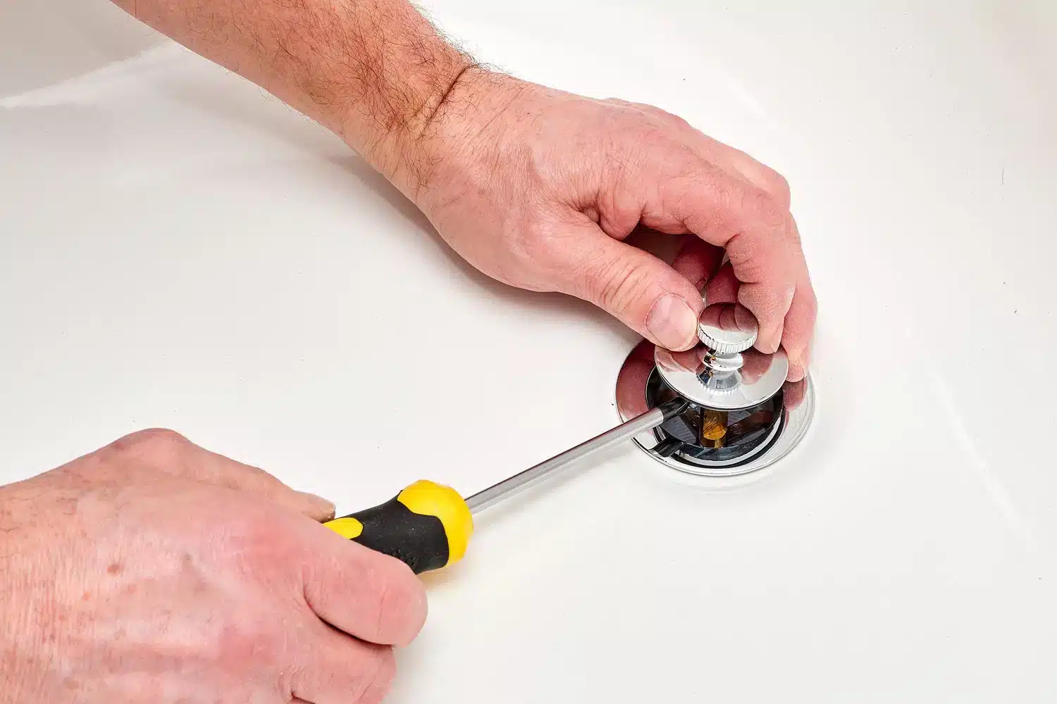 close up of male hands removing sink stopper