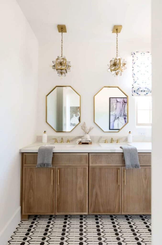 symmterical design in a bathroom with mirrors same light fixtures wooden vanity