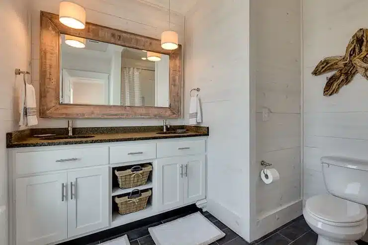 whitewashed wood vanity in bathroom white walls lights