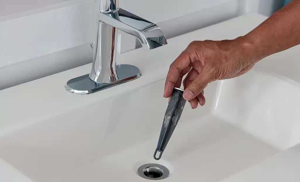 zoomed view of male hand working with sink stopper