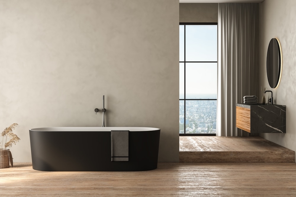 Modern bathroom interior with gray wall and travertine floor, black bathtub, marble basin, front view. 