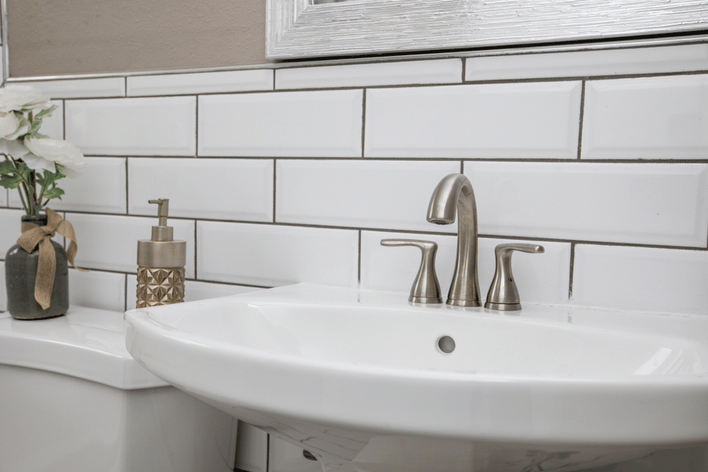 close up of a bathroom sink with subway tiles