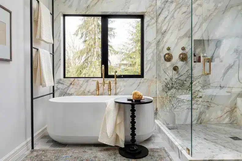 marble wall in a bathroom a bathtub towels hanging