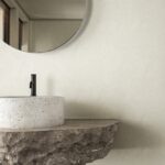 Minimalistic Bathroom Featuring A Natural Stone Countertop With A White