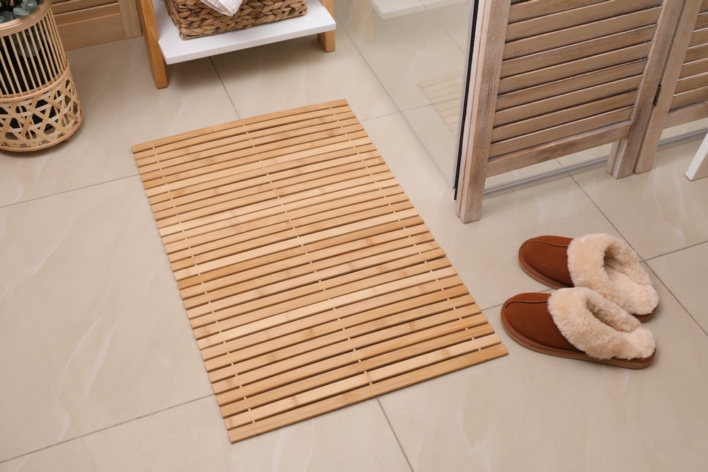 Wooden Mat And Slippers On Tiled Floor In Bathroom 